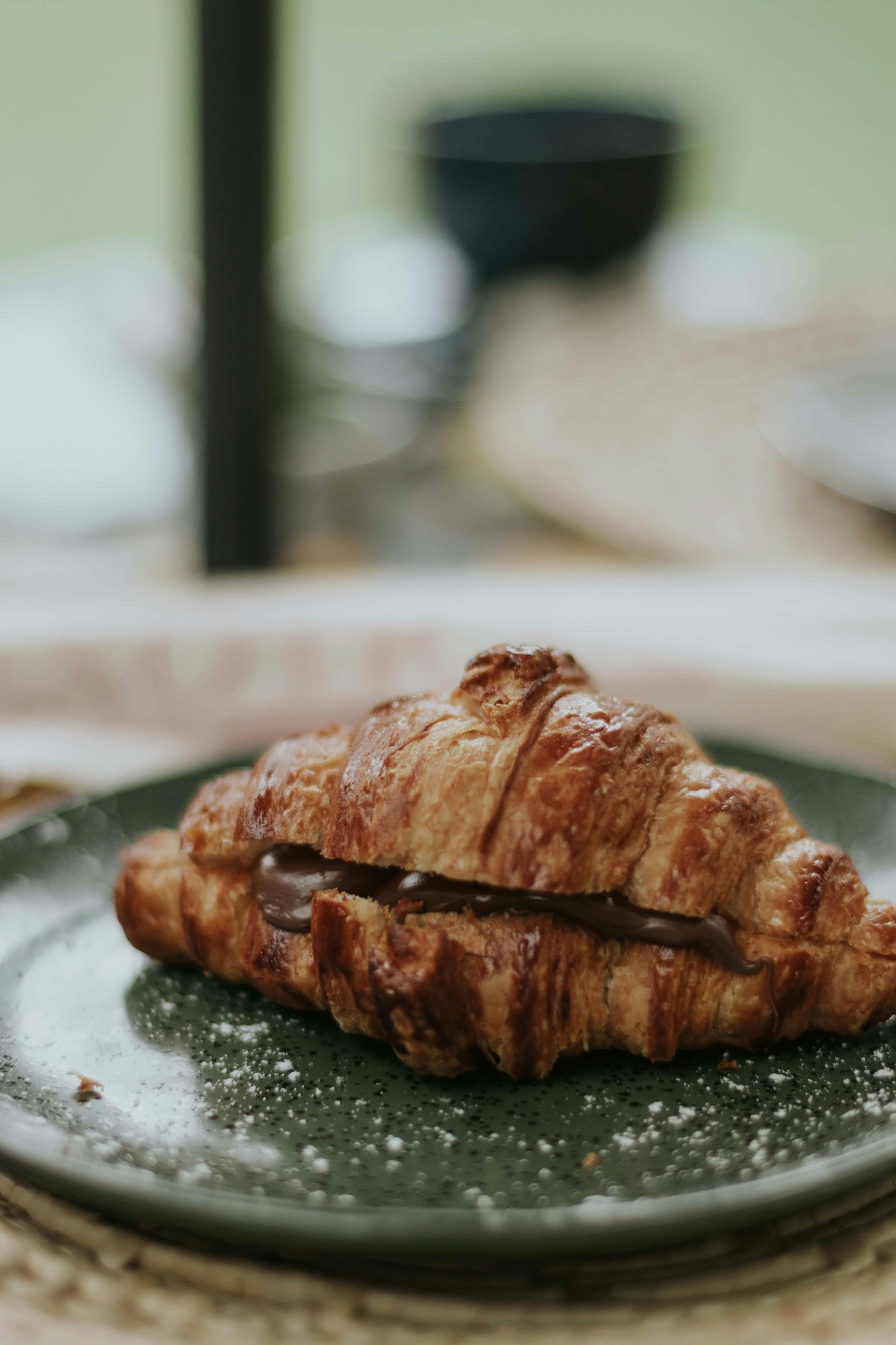 Un primo piano di un croissant su un piatto su un tavolo.
