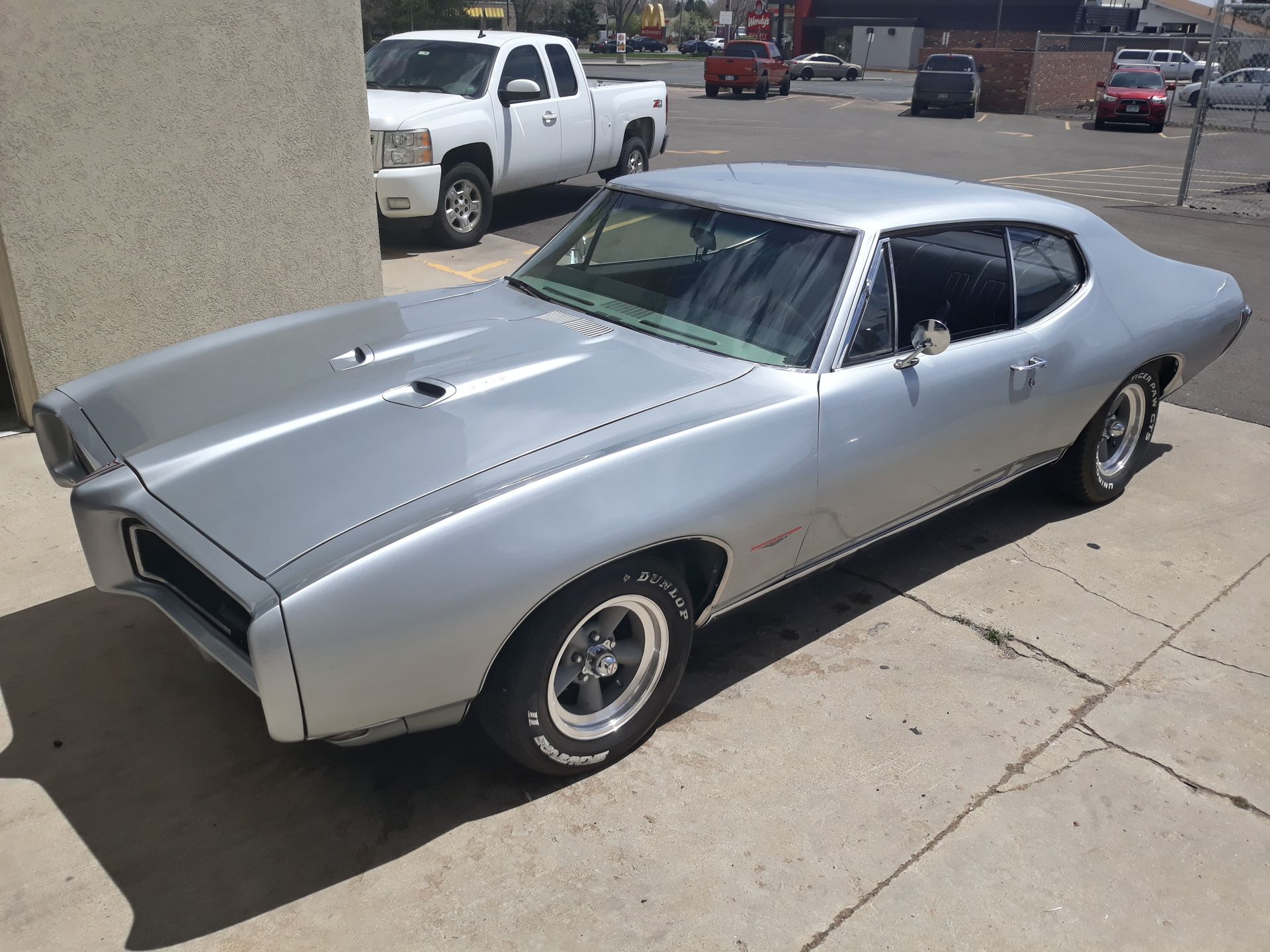 A silver car is parked on the side of the road