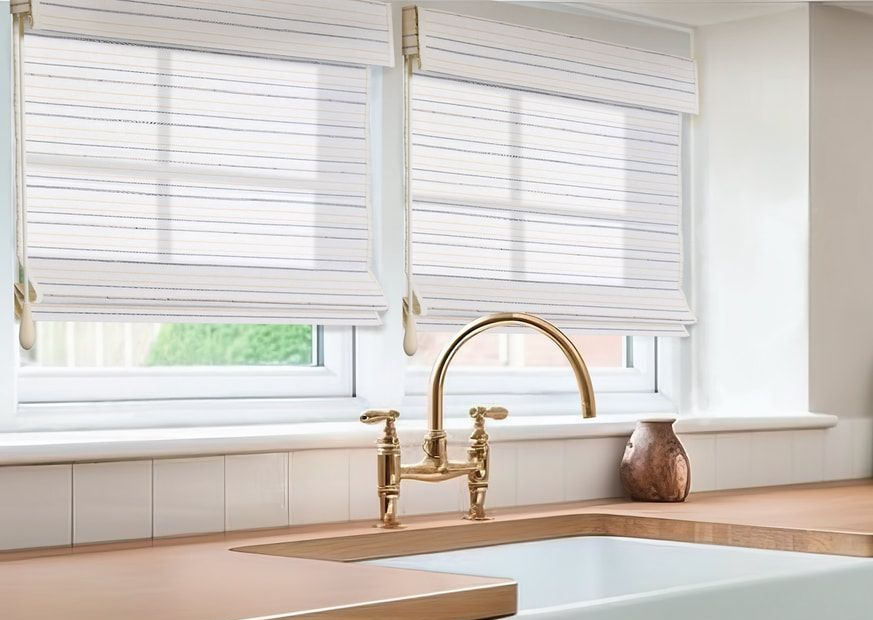 Kitchen with windows, white Arcadia Natural Shades Collection woven shades, gold faucet, and sink.