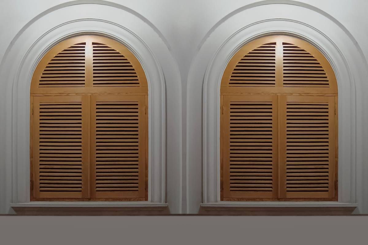 A pair of arched window blinds in a room near Manchester, NH