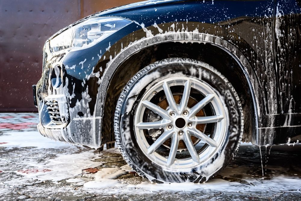 A close up of a car wheel covered in soap.