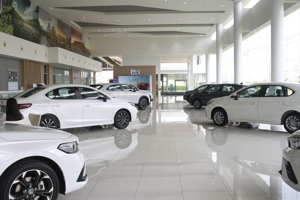 A lot of cars are parked in a showroom.