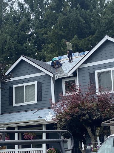 A man is standing on the roof of a house.