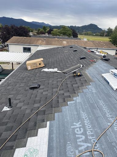 A roof is being installed on a house with mountains in the background.