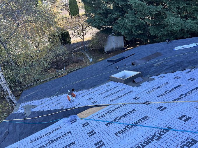 A roof is being covered with a roofing material.