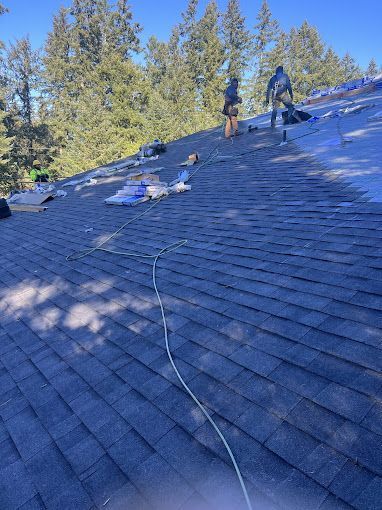 A group of people are working on the roof of a house.