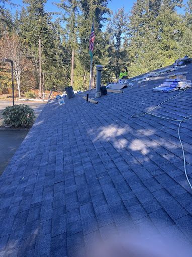 A roof with a flag on top of it and trees in the background.