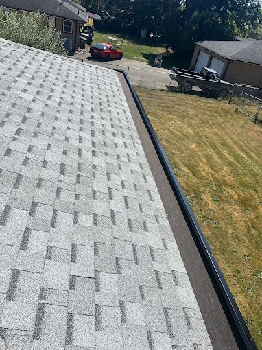A roof with a gutter on it and a car parked on the side of it.