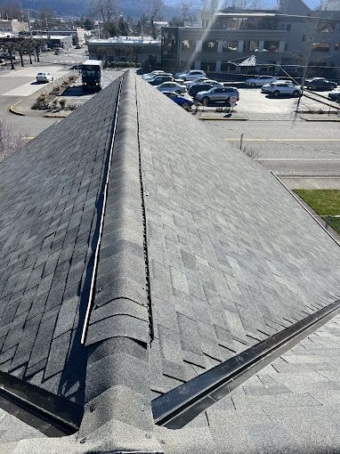 An aerial view of a roof with a parking lot in the background.