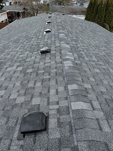 A roof with a lot of shingles and vents on it.