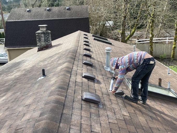 A man is working on the roof of a house.