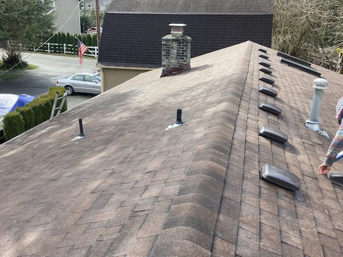 A man is working on the roof of a house