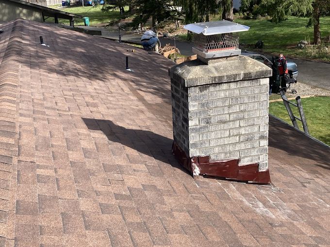 A brick chimney is sitting on top of a roof.