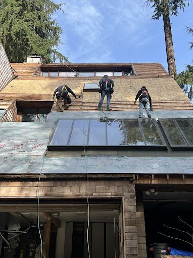 Two men are working on the roof of a house.
