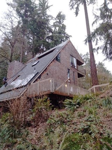 A brick house with a deck in the woods