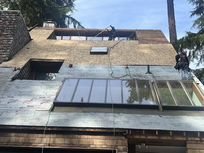 A man is working on the roof of a house.