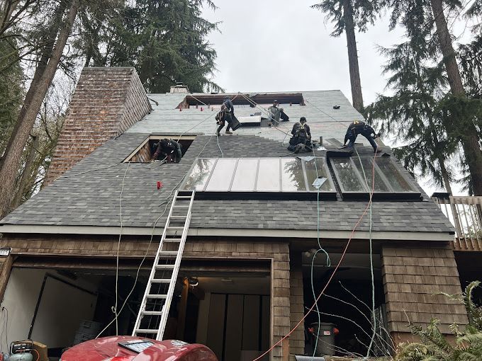 A group of people are working on the roof of a house.