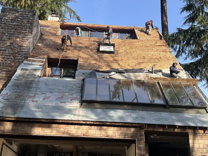 A group of people are working on the roof of a house.