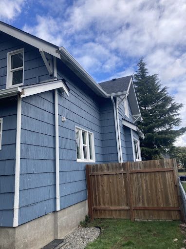 A blue house with a wooden fence in front of it.