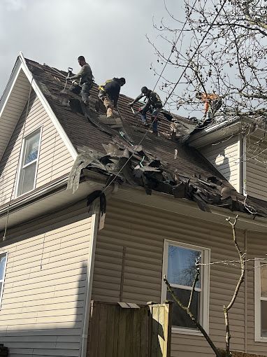 A group of men are working on the roof of a house.