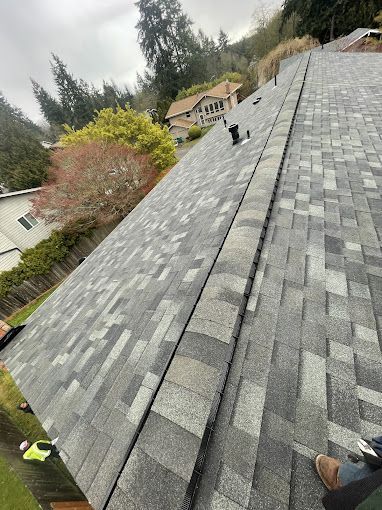 A person is standing on the roof of a house.