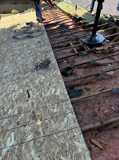A man is standing on top of a wooden roof.