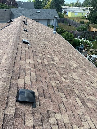 A roof with a lot of shingles and a chimney on it.