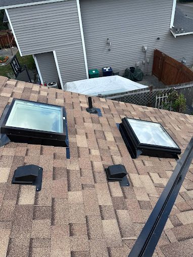 There are two skylights on the roof of a house.