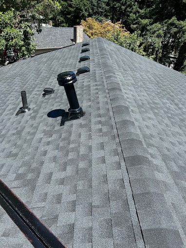 A close up of a roof with a chimney on it.
