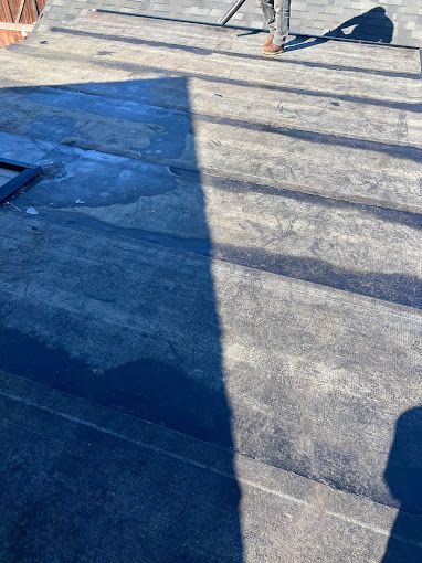 A person is standing on a roof with a broom.