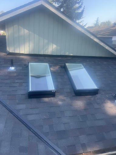 There are two skylights on the roof of a house.