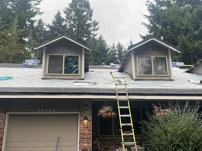 A ladder is sitting on the roof of a house.
