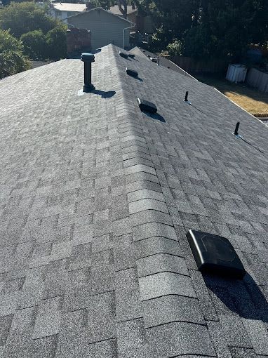 A close up of a roof with shingles and a chimney.