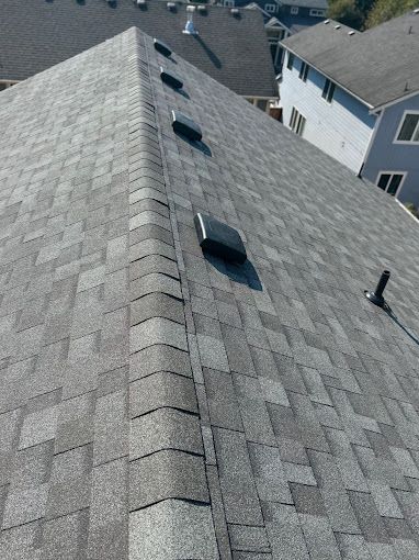 A roof with a lot of shingles and vents on it.