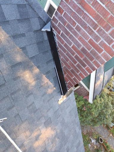 An aerial view of a brick house with a roof and chimney