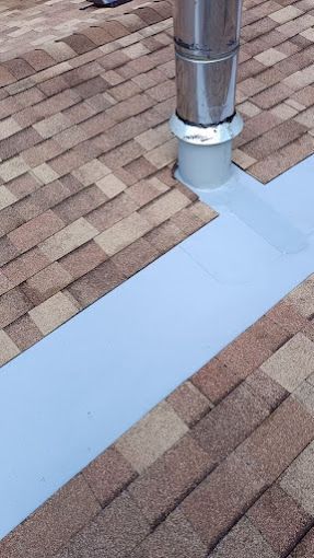 A chimney is sitting on top of a brick roof.