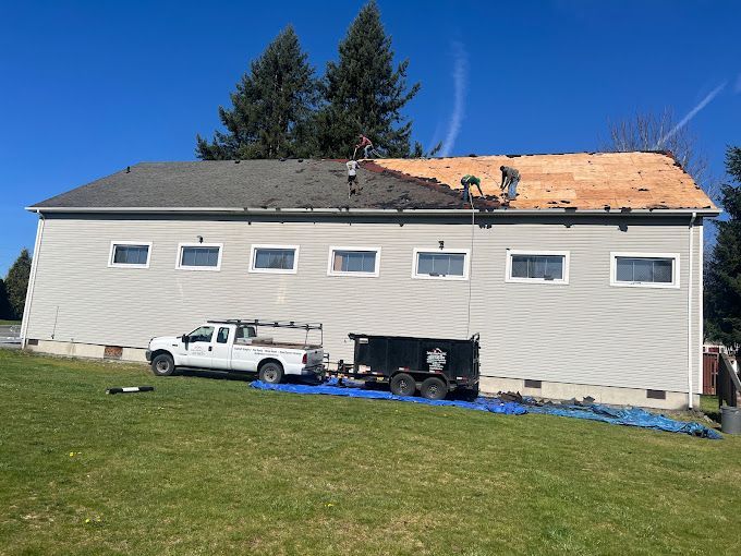 A white truck is parked in front of a large house.