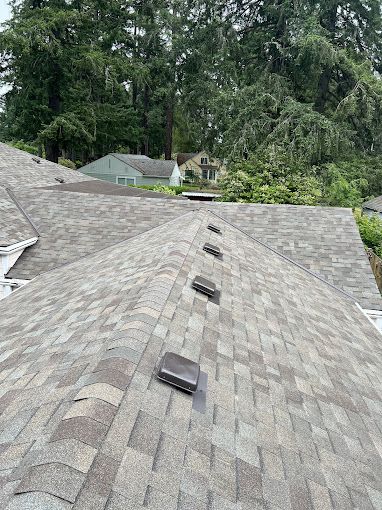 A roof with a lot of shingles and vents on it.
