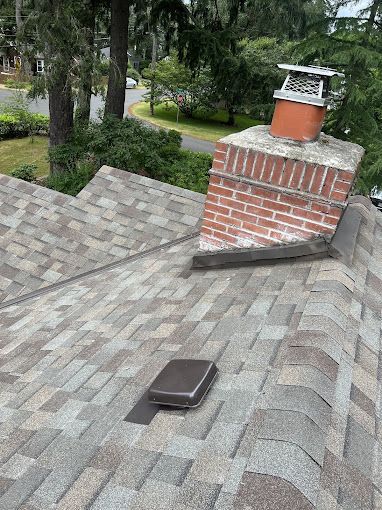 A roof with a brick chimney on top of it.