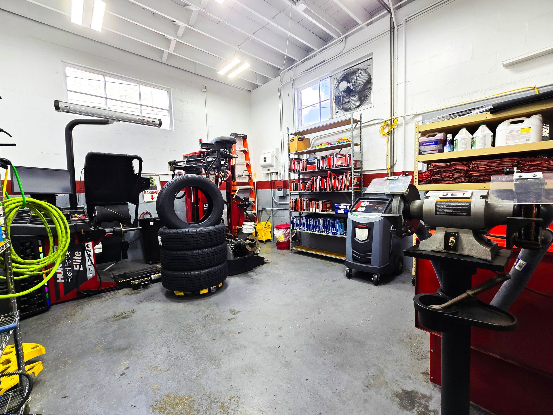 Interior of a car repair shop with tire equipment, shelves of parts, and various tools. | Johnny's Automotive