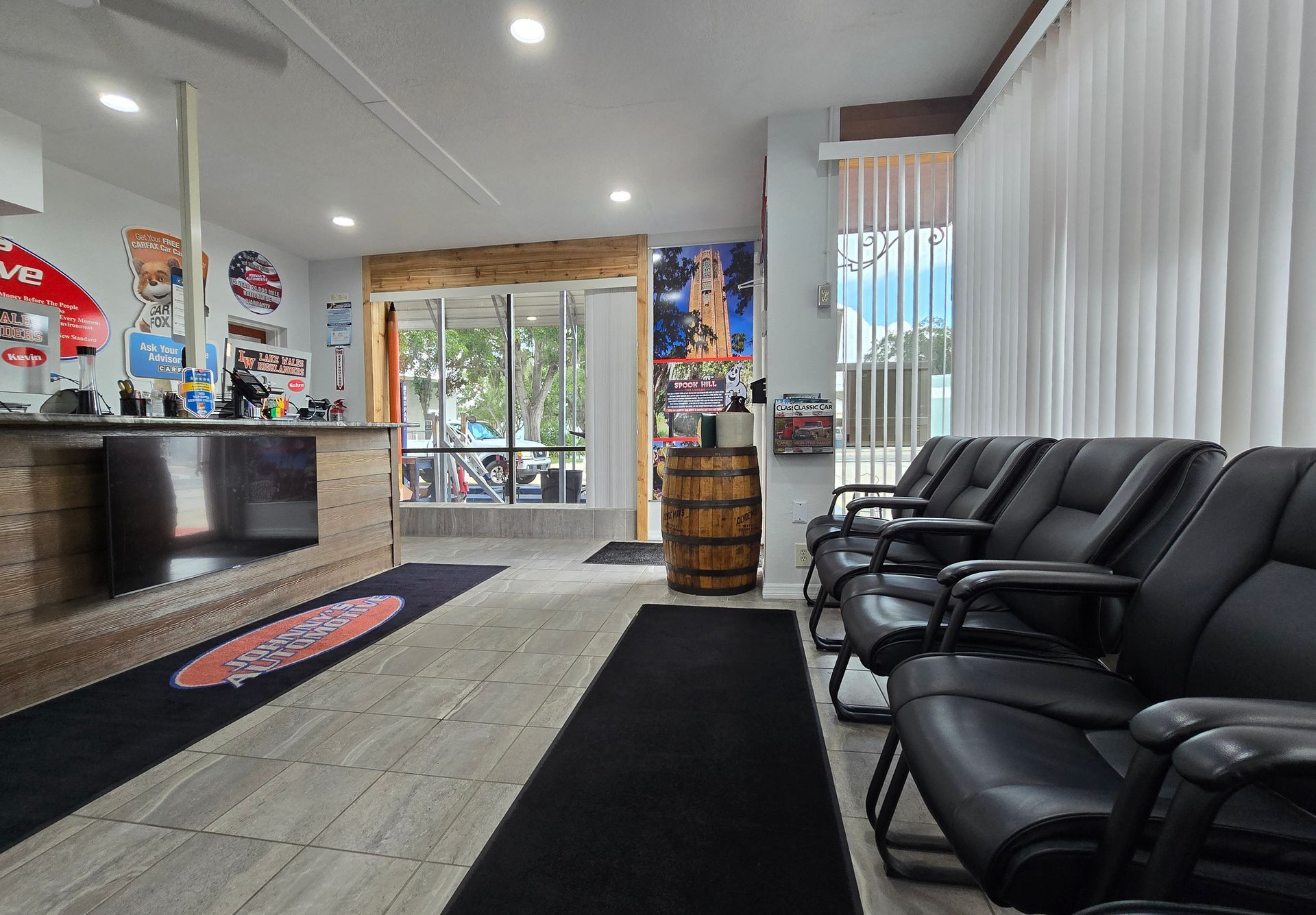 Interior of a barber shop with waiting area and reception. Chairs are black and the walls are mostly white. | Johnny's Automotive