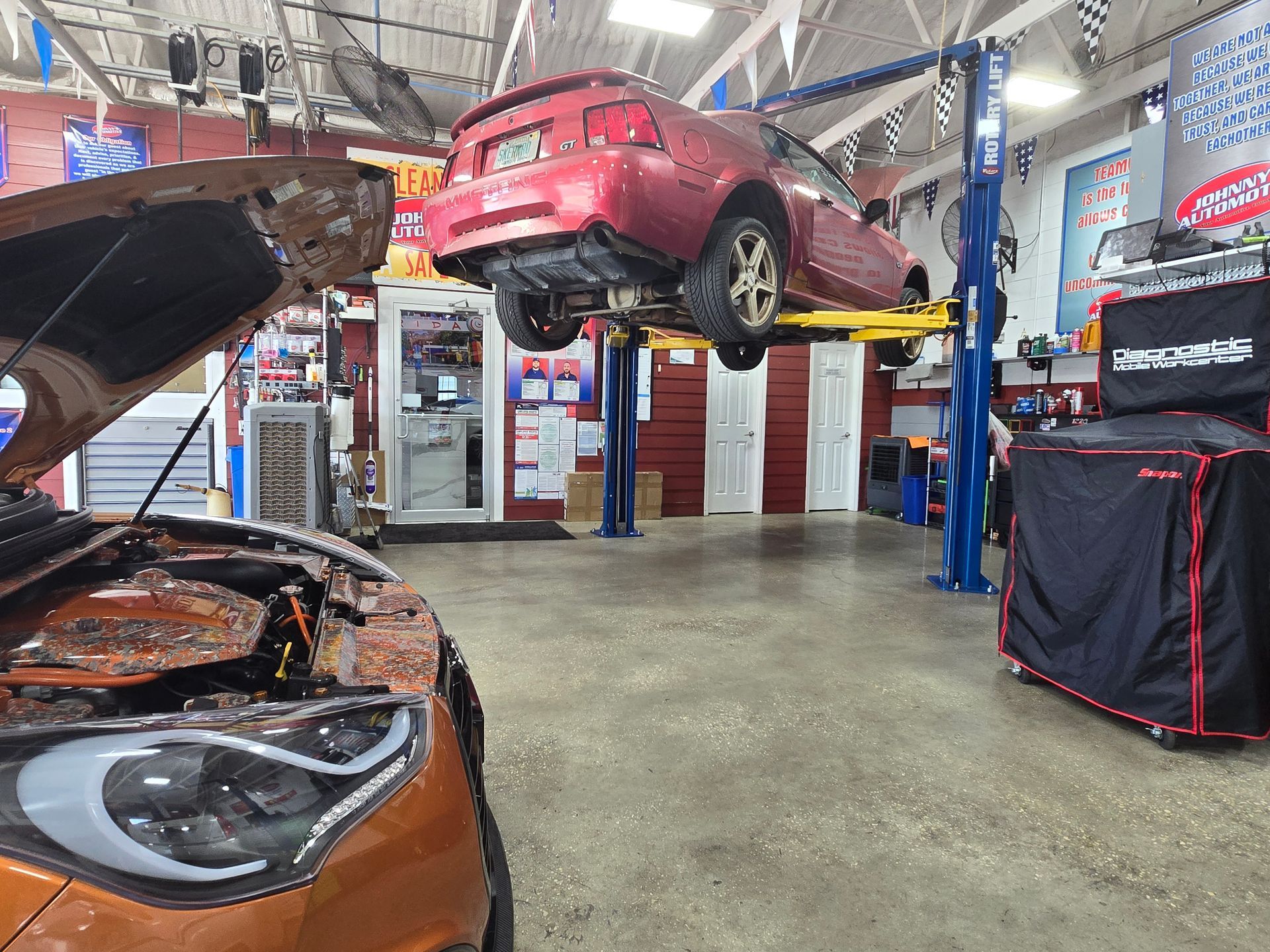 Car being repaired in auto shop with another car. | Johnny's Automotive