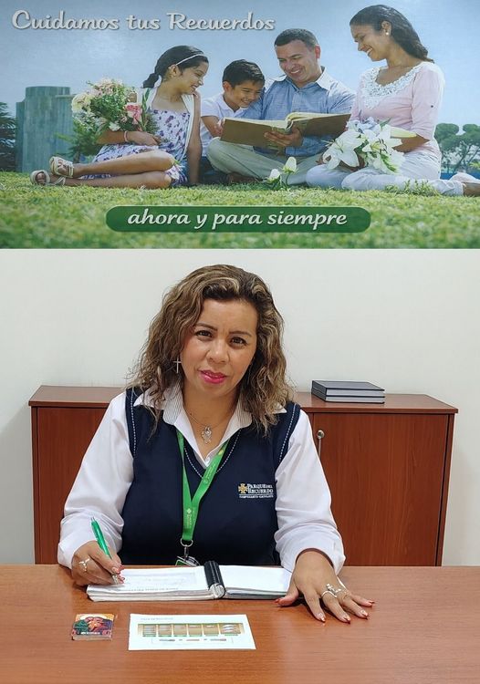 Mujer sentada en un escritorio firmando papeles debajo de un póster con temática familiar en la pared.