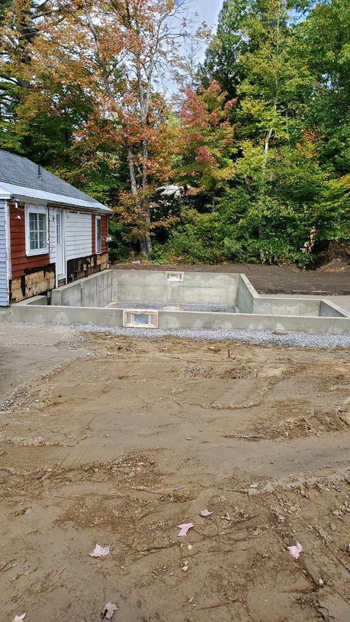 A house is being built in the middle of a dirt field.