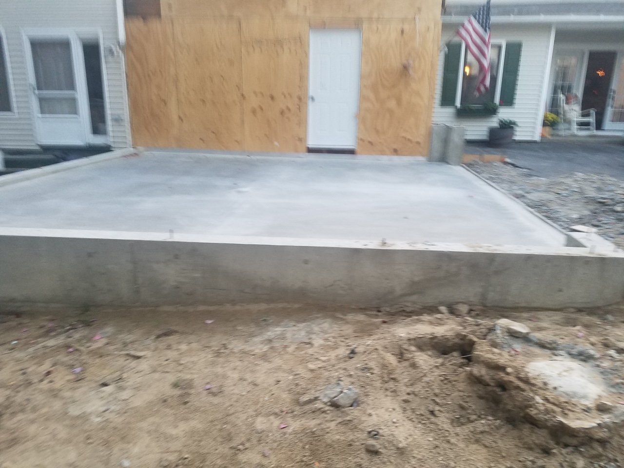 A concrete driveway is being built in front of a house.