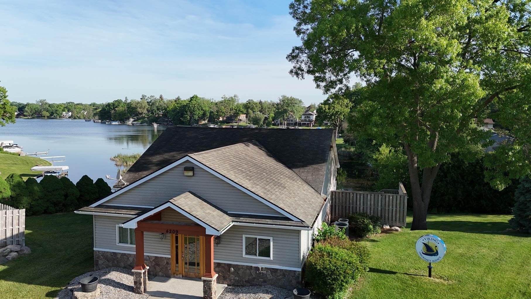 An aerial view of a house with a lake in the background.