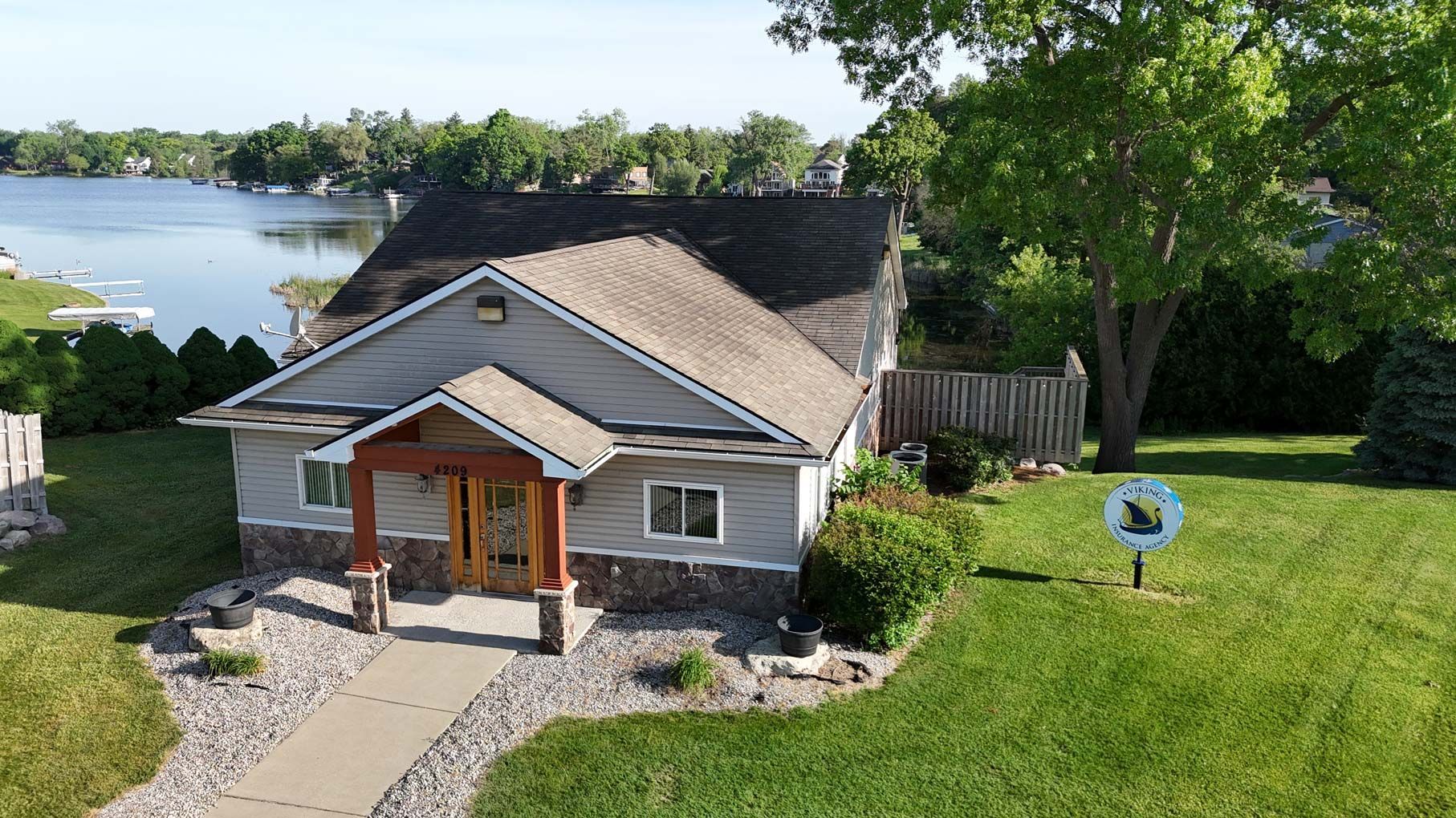 An aerial view of a house with a lake in the background.