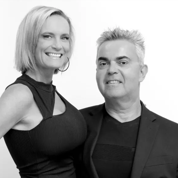 A man and a woman are posing for a picture in a black and white photo.