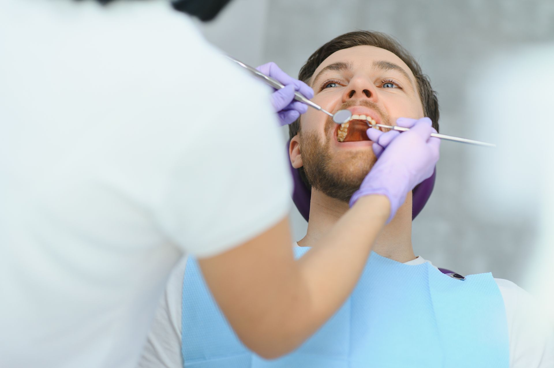Dentist using a syringe to administer dental treatment to a patient in a clinic