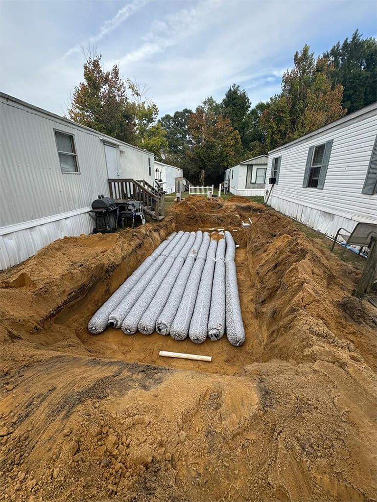 Dug trench with buried, wrapped pipes. 